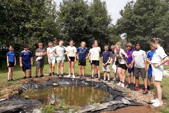 Image of Year 6 pupils at St Cuthbert's Catholic Primary School Botcherby with new school pond