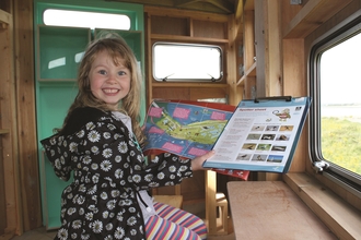 Image of girl in hide at South Walney Nature Reserve credit Cumbria Wildlife Trust