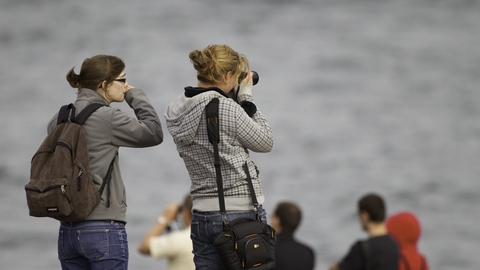 Two women waiting on Chanonry Point beach hoping to see dolphins, Fortrose, Scotland. copyright Peter Cairns/2020VISION