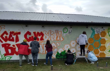 Image of young people painting Get Cumbria Buzzing mural, Salterbeck