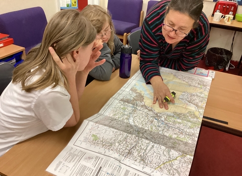 teacher and pupils looking at map