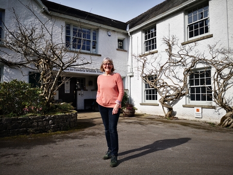 A woman standing in front of the Cumbria Wildlife Trust building. 