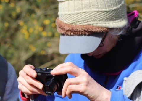 A woman taking a picture with a small camera