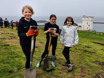 Image of three girls with spades at the Big Buzz credit Cumbria Wildlife Trust