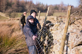 image of Volunteers putting up a fence