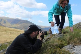 Photographer taking close-up picture of rock