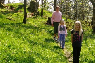Family walking down path in Craggy Wood near Staveley