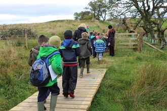 School children crossing bridge at Eycott Hill Nature Reserve