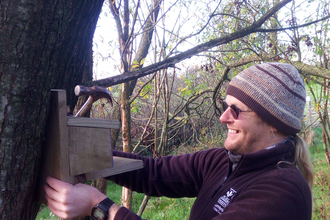 Image of volunteer John Rowlands fixing red squirrel feeder at Smardale Nature Reserve