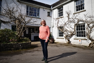 A woman standing in front of the Cumbria Wildlife Trust building. 