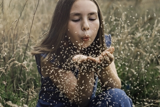 Image of young girl blowing seeds credit Tom and Evie Photography