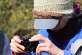 A woman taking a picture with a small camera