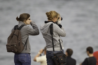 Two women waiting on Chanonry Point beach hoping to see dolphins, Fortrose, Scotland. copyright Peter Cairns/2020VISION