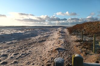 A view of a path along the edge of the beach and dunes at South Walney during frosty weather