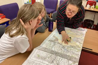 teacher and pupils looking at map