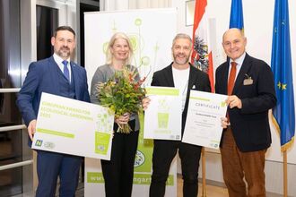 Four people at Natur im Garten holding up award certificates and flowers