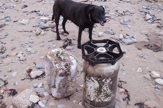 An old bear barrel and large plastic container washed ashore
