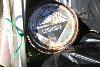 Tin with corrosive warning label