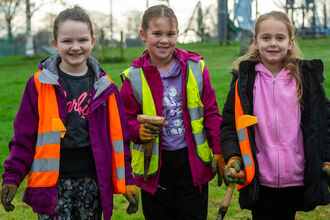 Three young girls with garden tools at a planting day in Ulverston