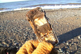 An old Mobile phone buried in the sand