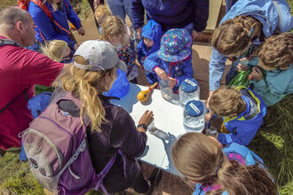 children at cold springs event filling jars containers with water