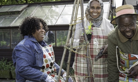 Individuals from the Asian ethnic group and Black ethnic group outside gardening 