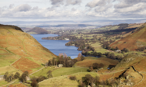 Photo shows the fells overlooking Ullswater, which is vibrant blue.