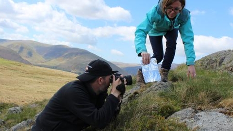 Photographer taking close-up picture of rock