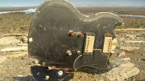 Old Broken guitar found in the sand