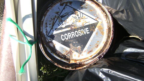 Tin with corrosive warning label