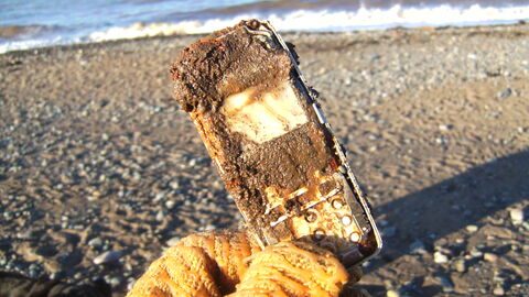 An old Mobile phone buried in the sand