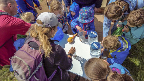 children at cold springs event filling jars containers with water