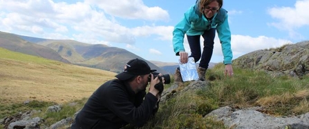 Photographer taking close-up picture of rock