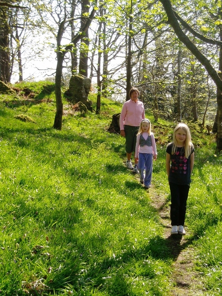 Family walking down path in Craggy Wood near Staveley