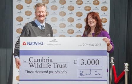 image of Paul Currie,of The Lakes Distillery presenting Michelle Waller with donation
