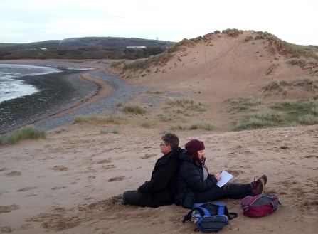 Image of two people drawing on beach credit Cumbria Wildlife Trust