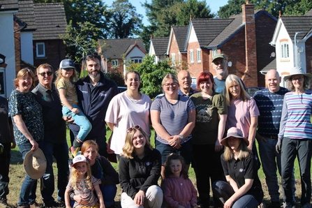A group of volunteers in a park and smiling at camera