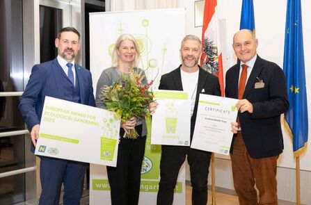 Four people at Natur im Garten holding up award certificates and flowers