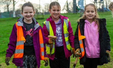 Three young girls with garden tools at a planting day in Ulverston