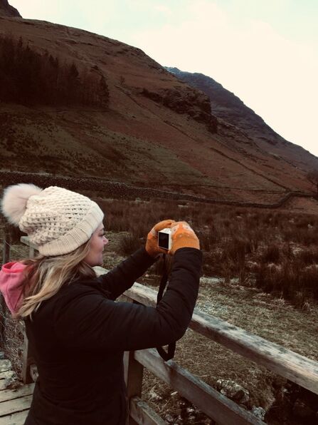 Girl outdoors in winter taking photo with camera 