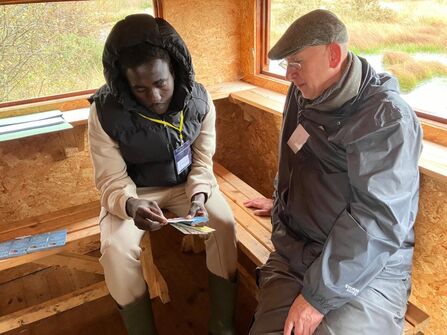 People looking at a leaflet in a nature reserve hide