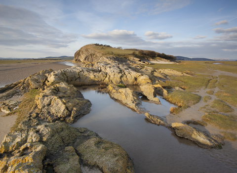 image of Limestone outcrop on edge of saltmarsh and mudflats at Humphrey Head onMorecambe Bay in Cumbria