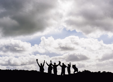 a group of people sillhouetted on hillside copyright Evie and Tom photography